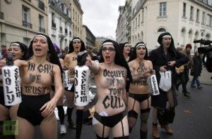 Topless activists of the Ukrainian women movement Femen take part in a protest against the fierce opposition from the Roman Catholic Church to authorise gay marriage on November 18, 2012 in Paris. AFP PHOTO KENZO TRIBOUILLARD